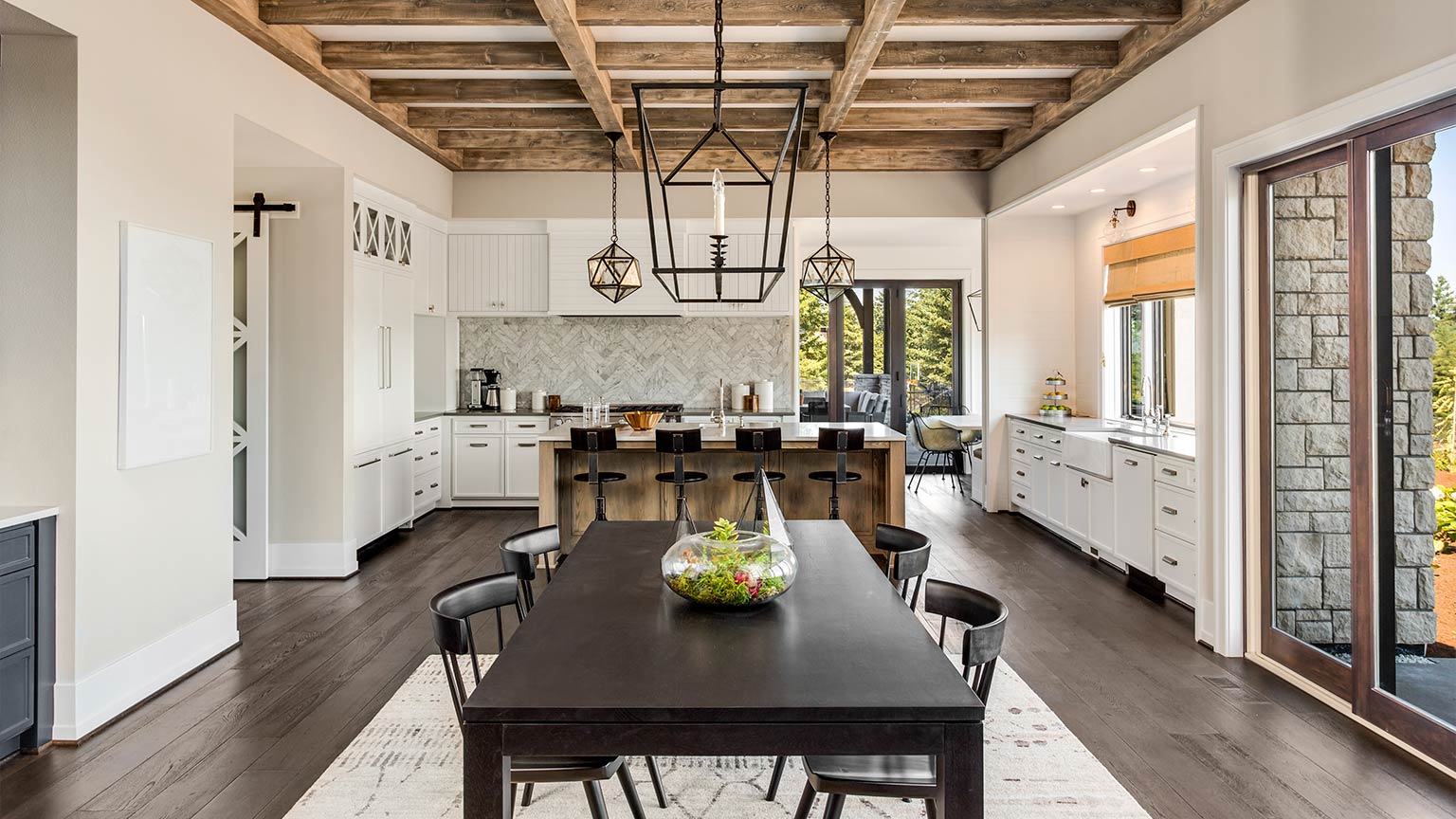 luxury kitchen and dining room with wood beams and elegant pendant lights