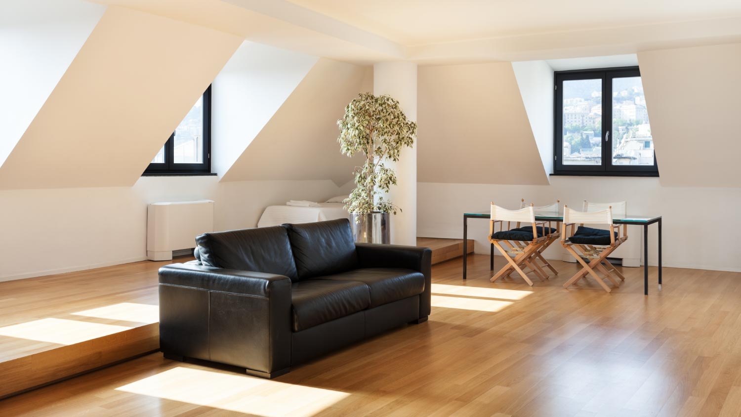 A nice attic with a black sofa 