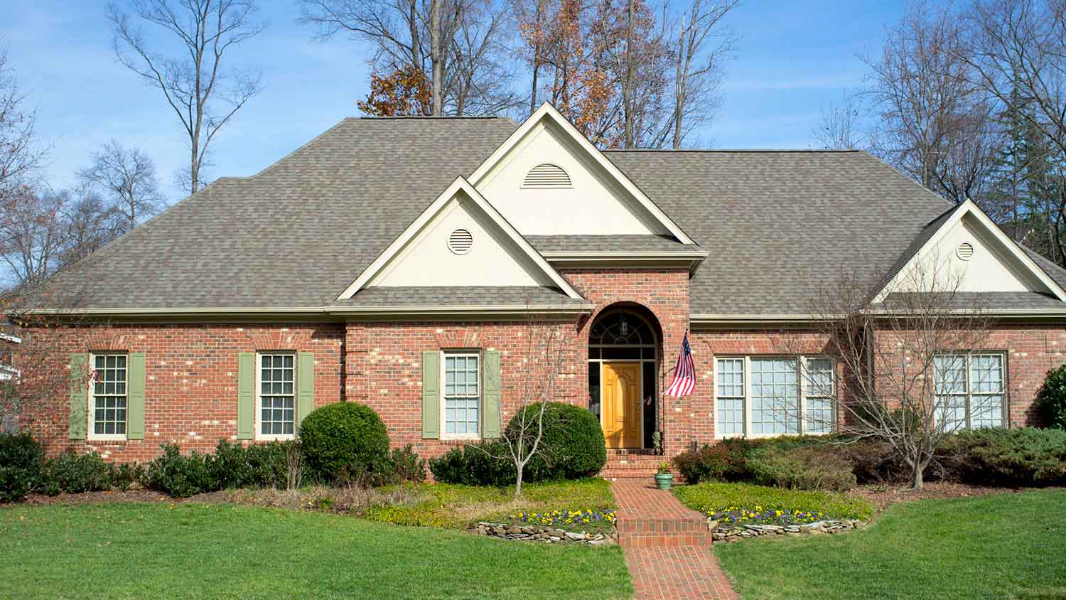 One story brick house with green window shutters