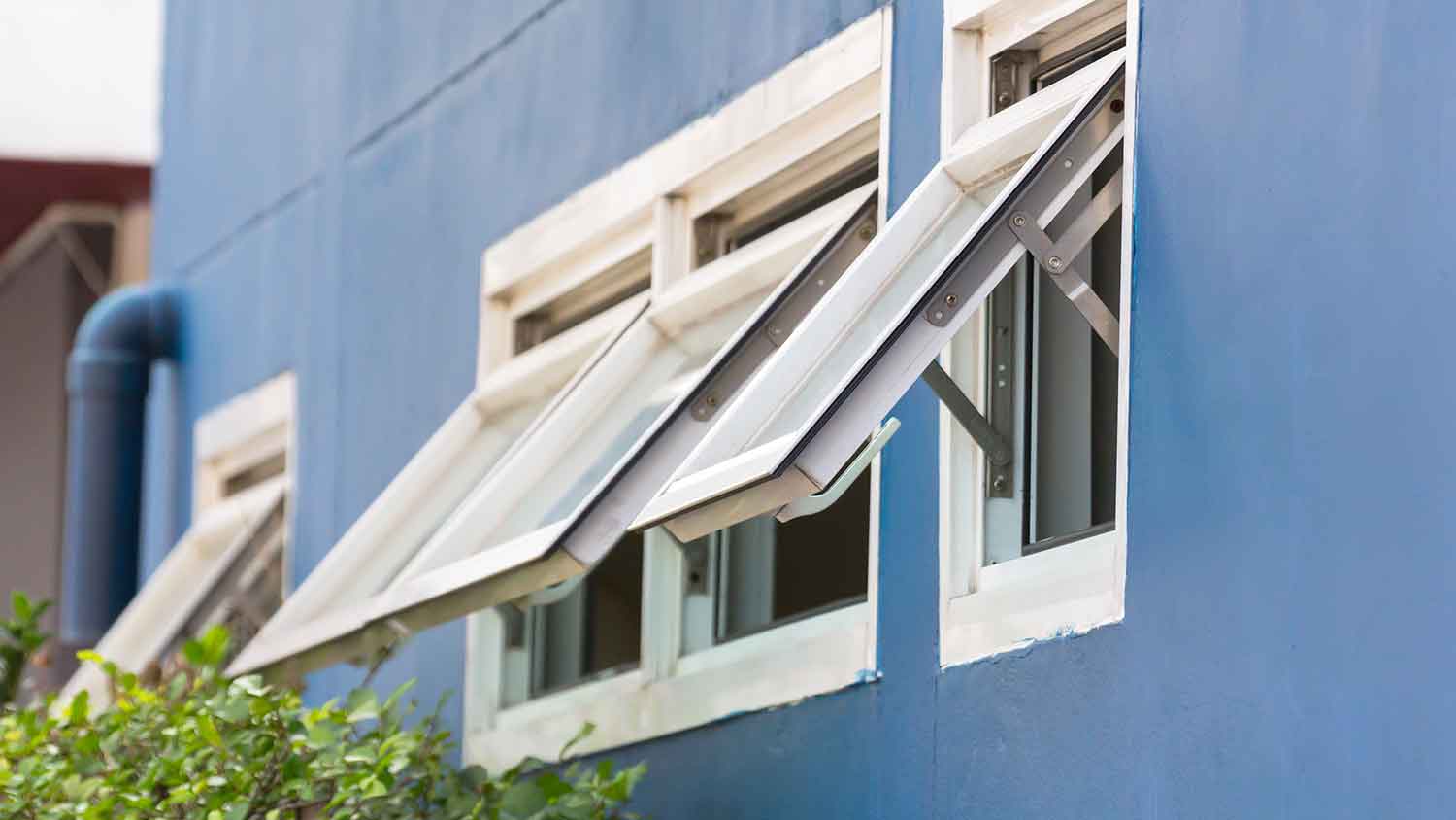 Top-hinged casement windows in a blue wall