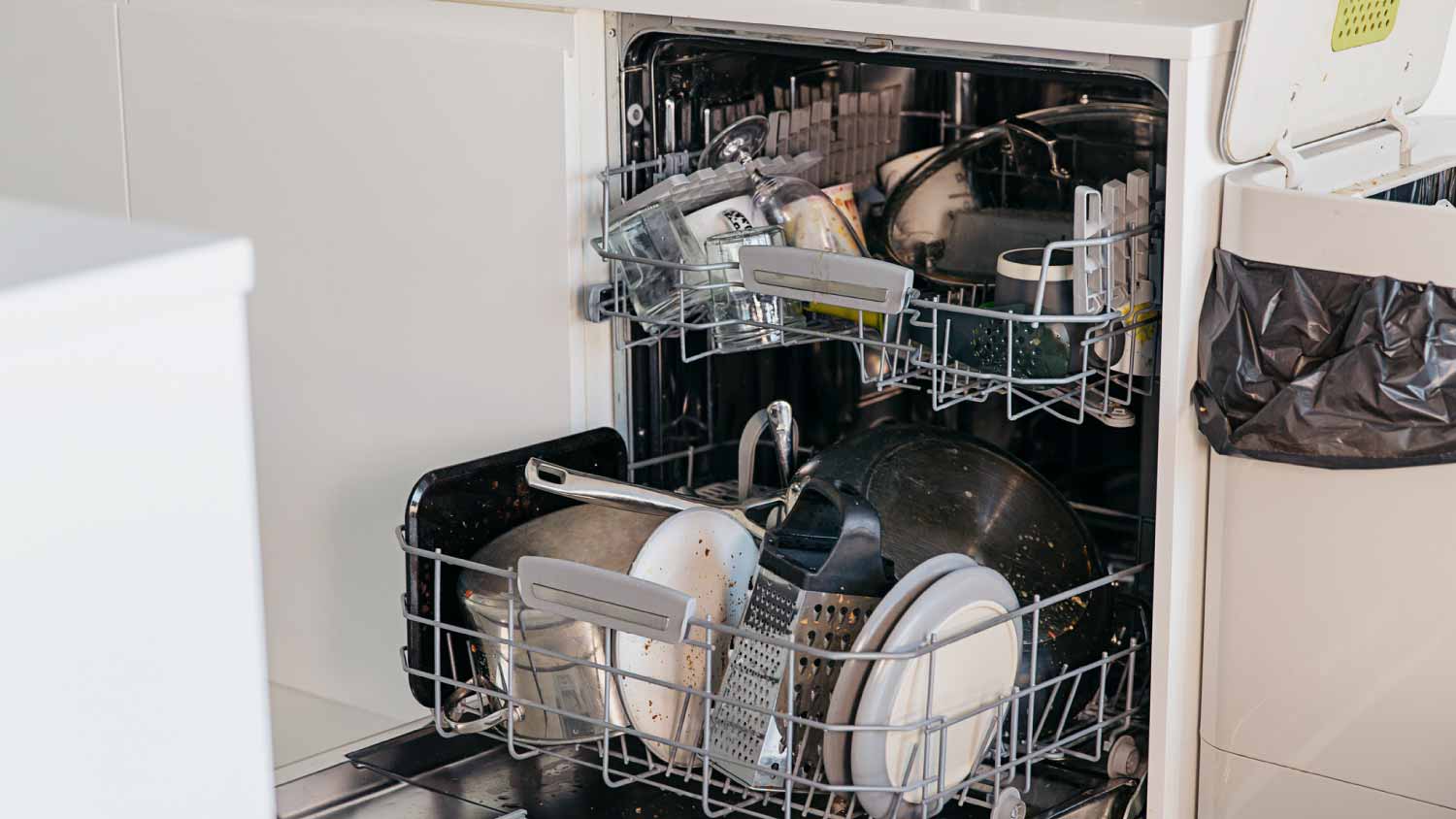 An open dishwasher full of dishes