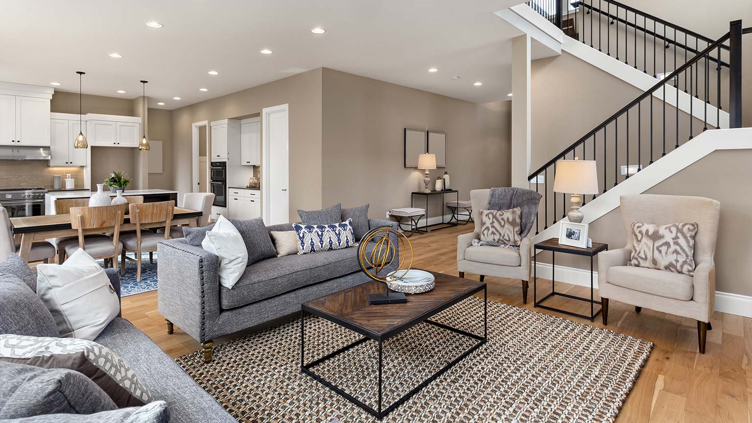 Beautiful living room interior with hardwood floors and and view of kitchen in new luxury home