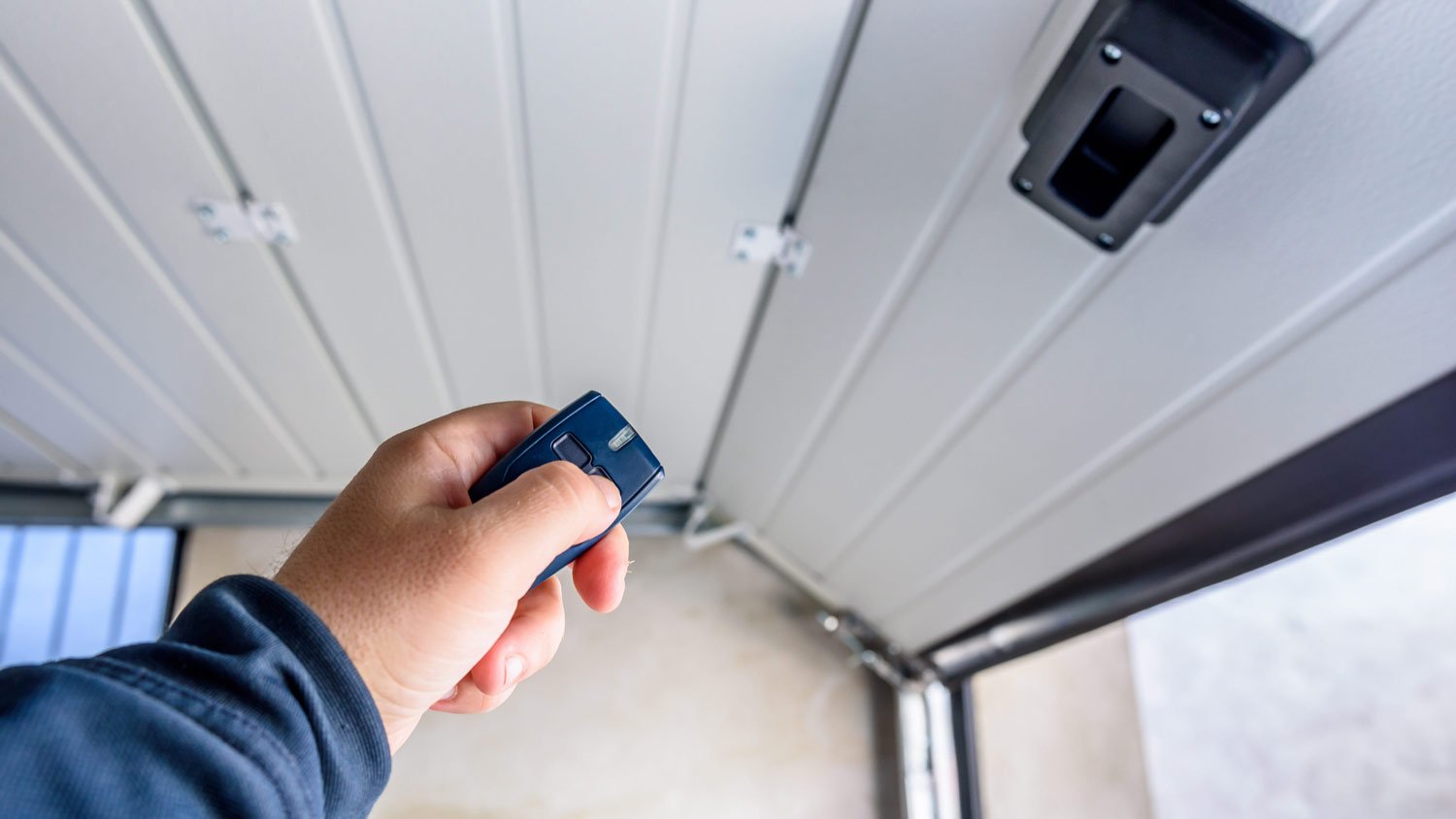 man using remote control to open garage