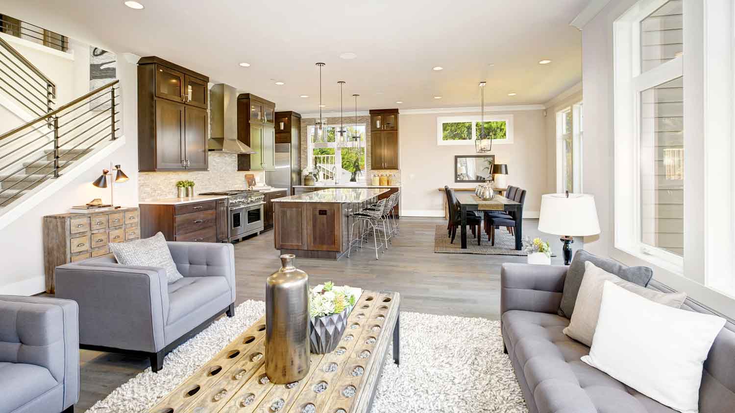 An open plan living room and kitchen with gray furniture