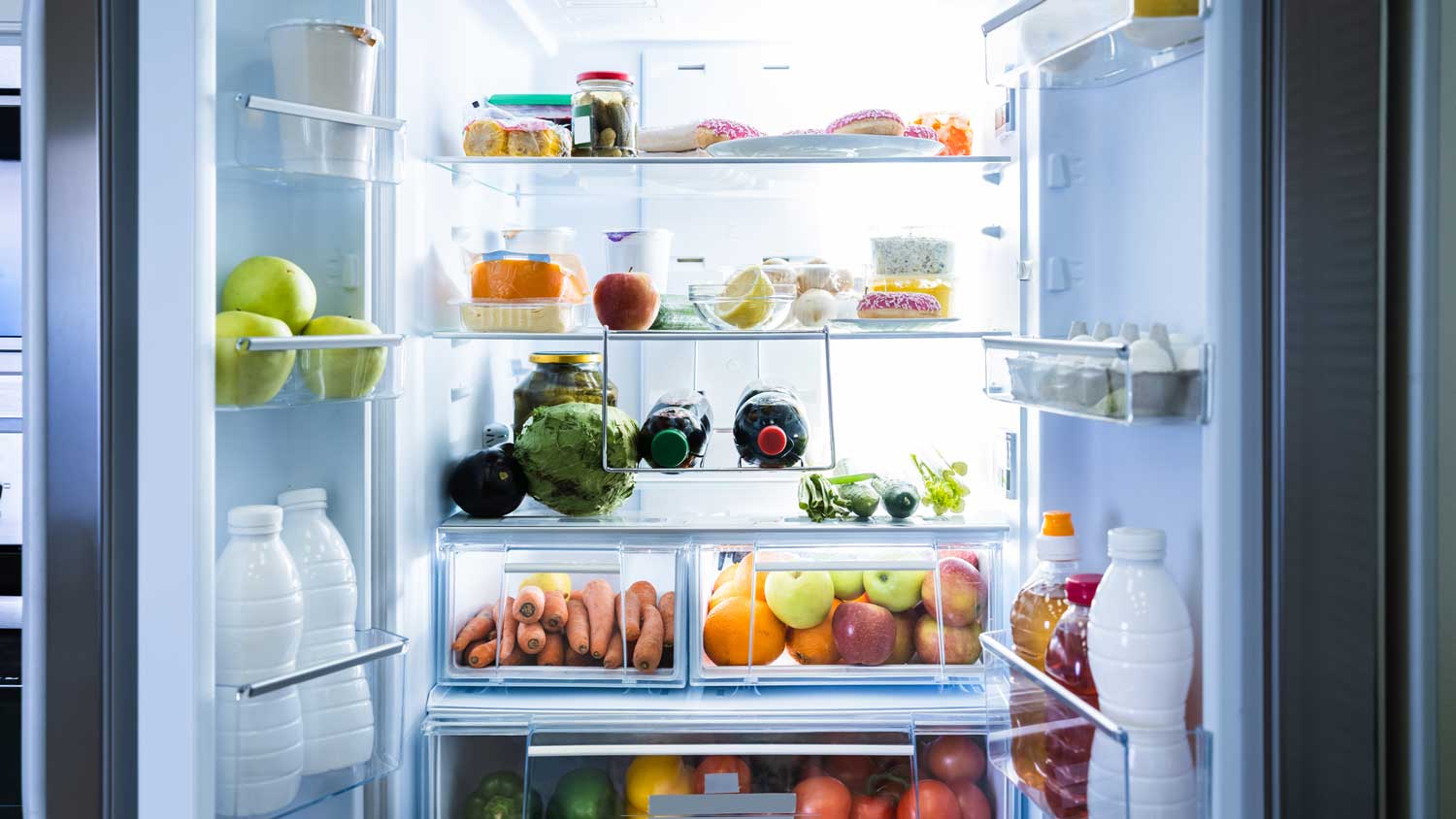 An open refrigerator with lots of fruit and vegetables