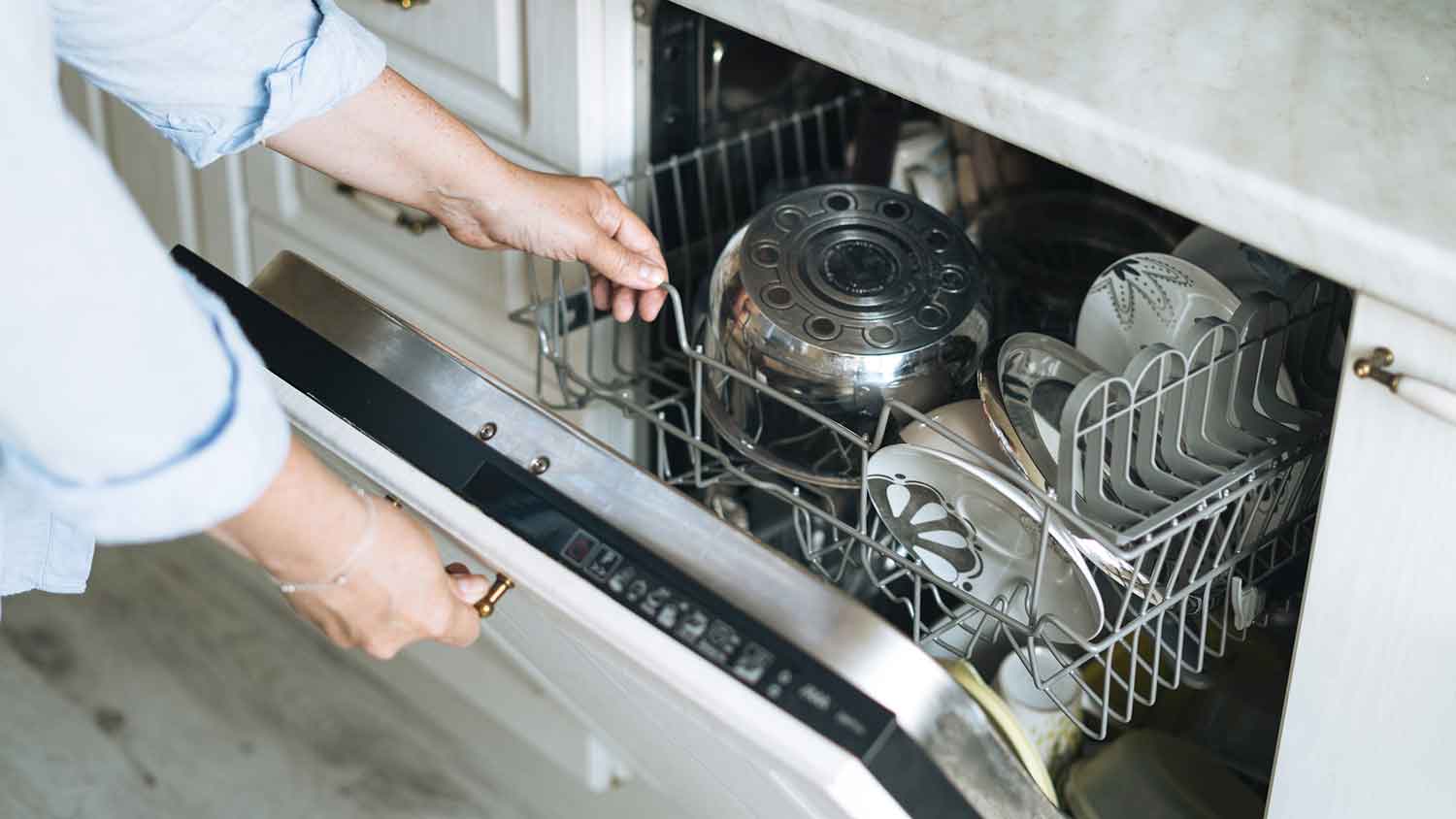 A person opening a dishwasher