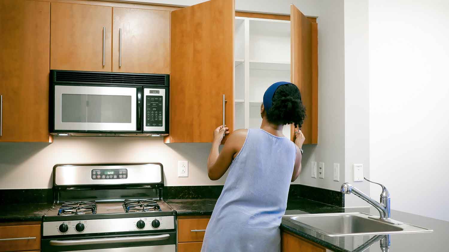 Woman looking around empty kitchen