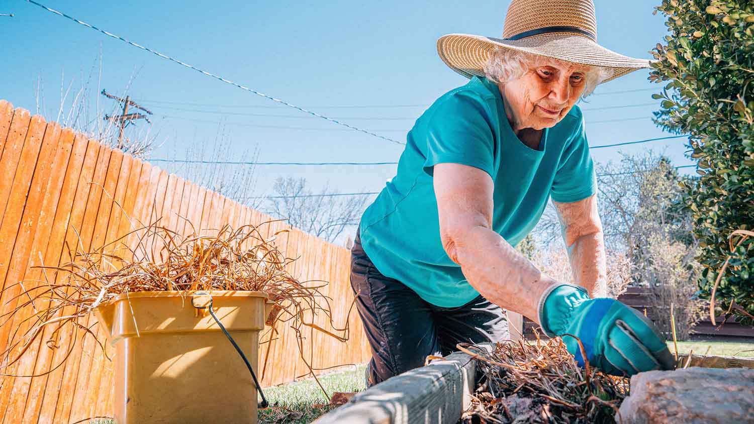 Woman picking up twigs in the yard