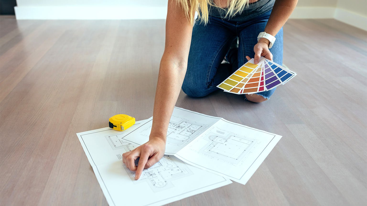 Young woman looking house plans on the floor