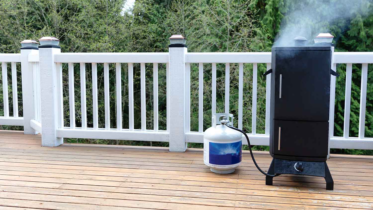 Propane tank connected to an outdoor smoker