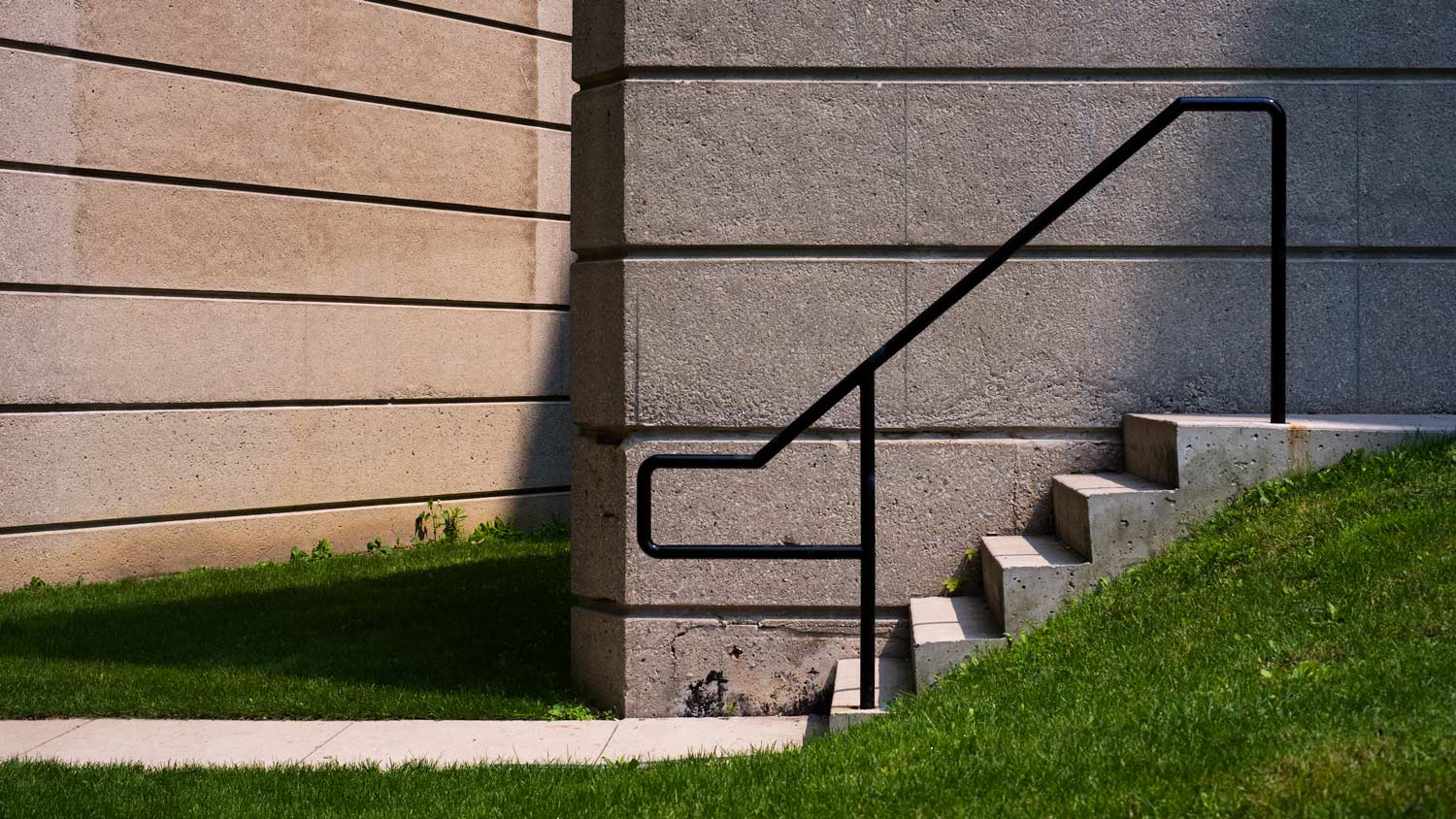 Graphic image of concrete stairs and black railing.