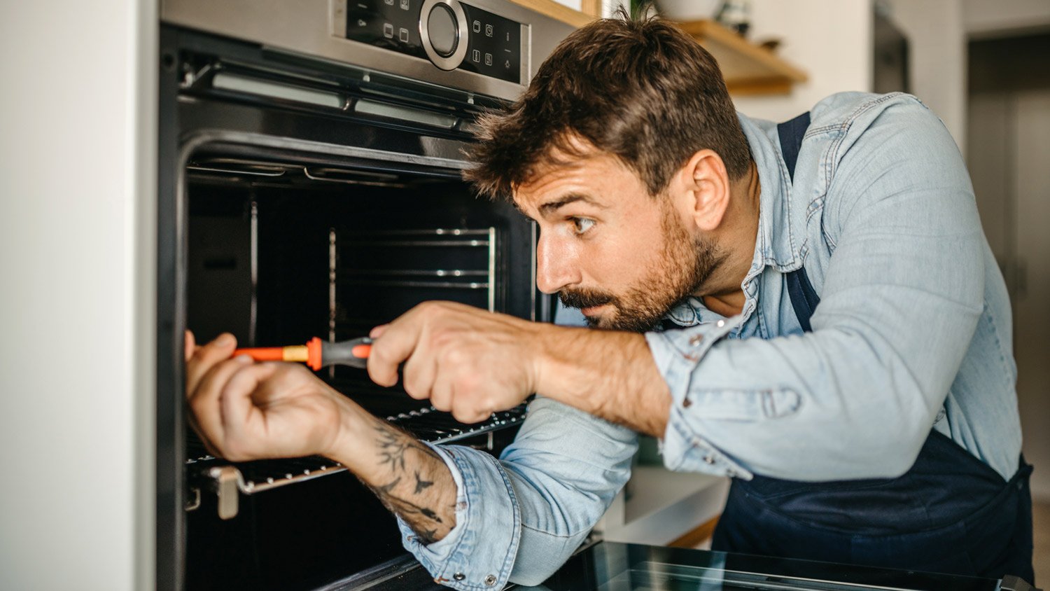 Professional handyman fixing oven