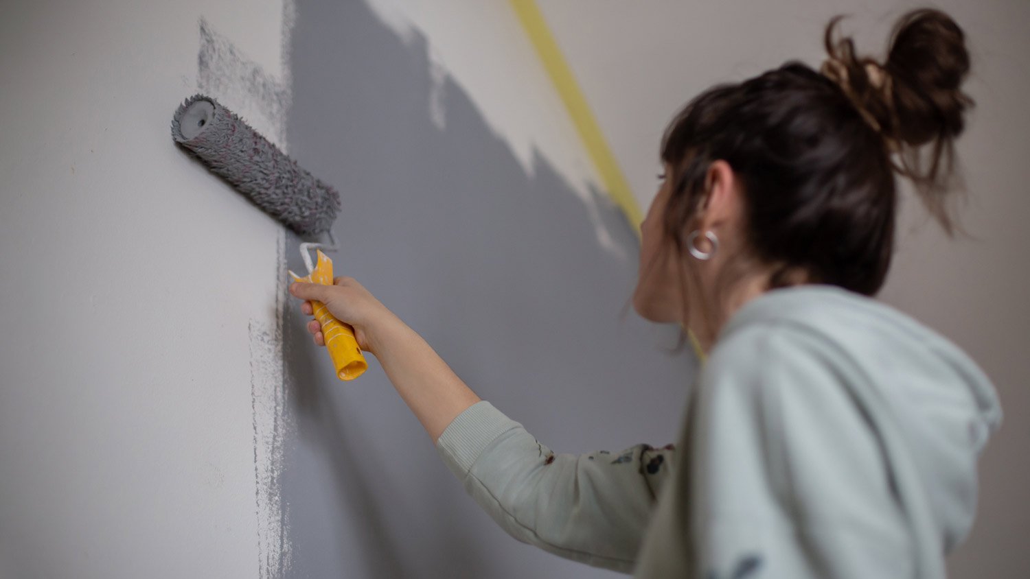 woman painting interior wall