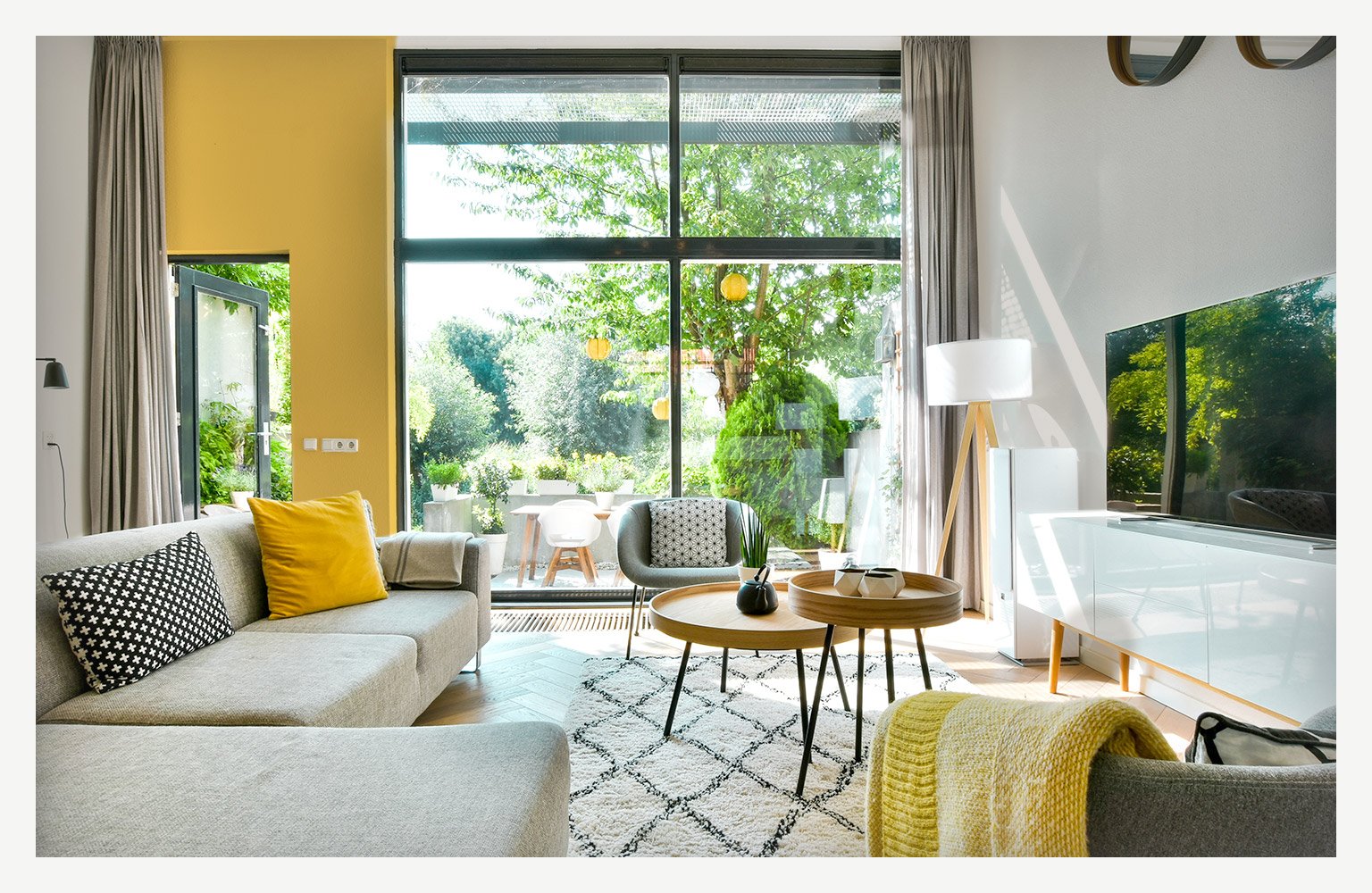 living room with couch and TV and big open windows 