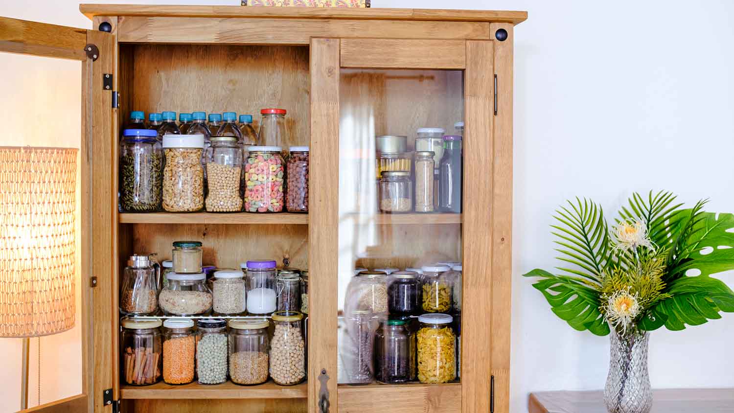 Jars with food in pantry cabinet