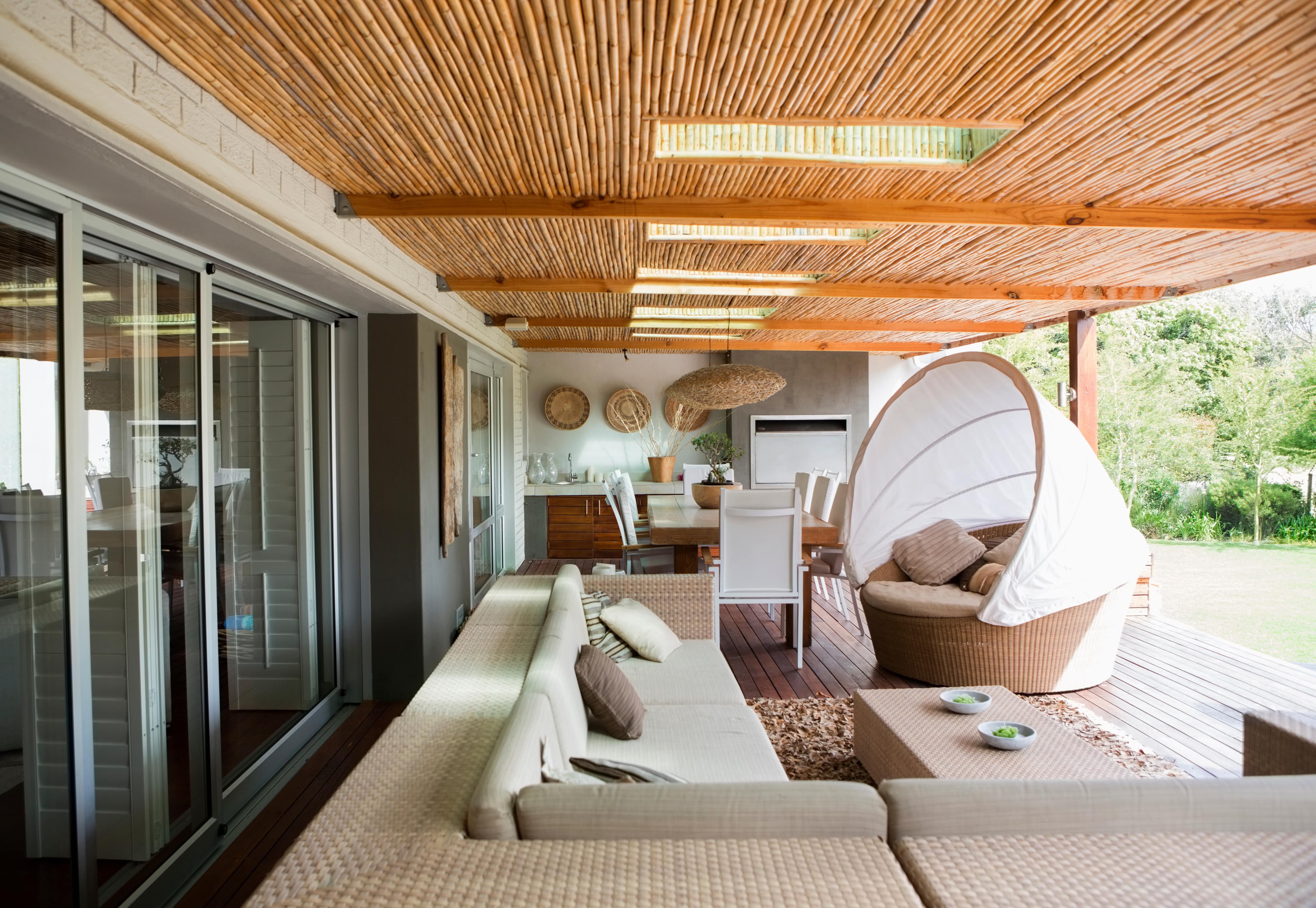 A modern bamboo-covered patio with living and dining areas