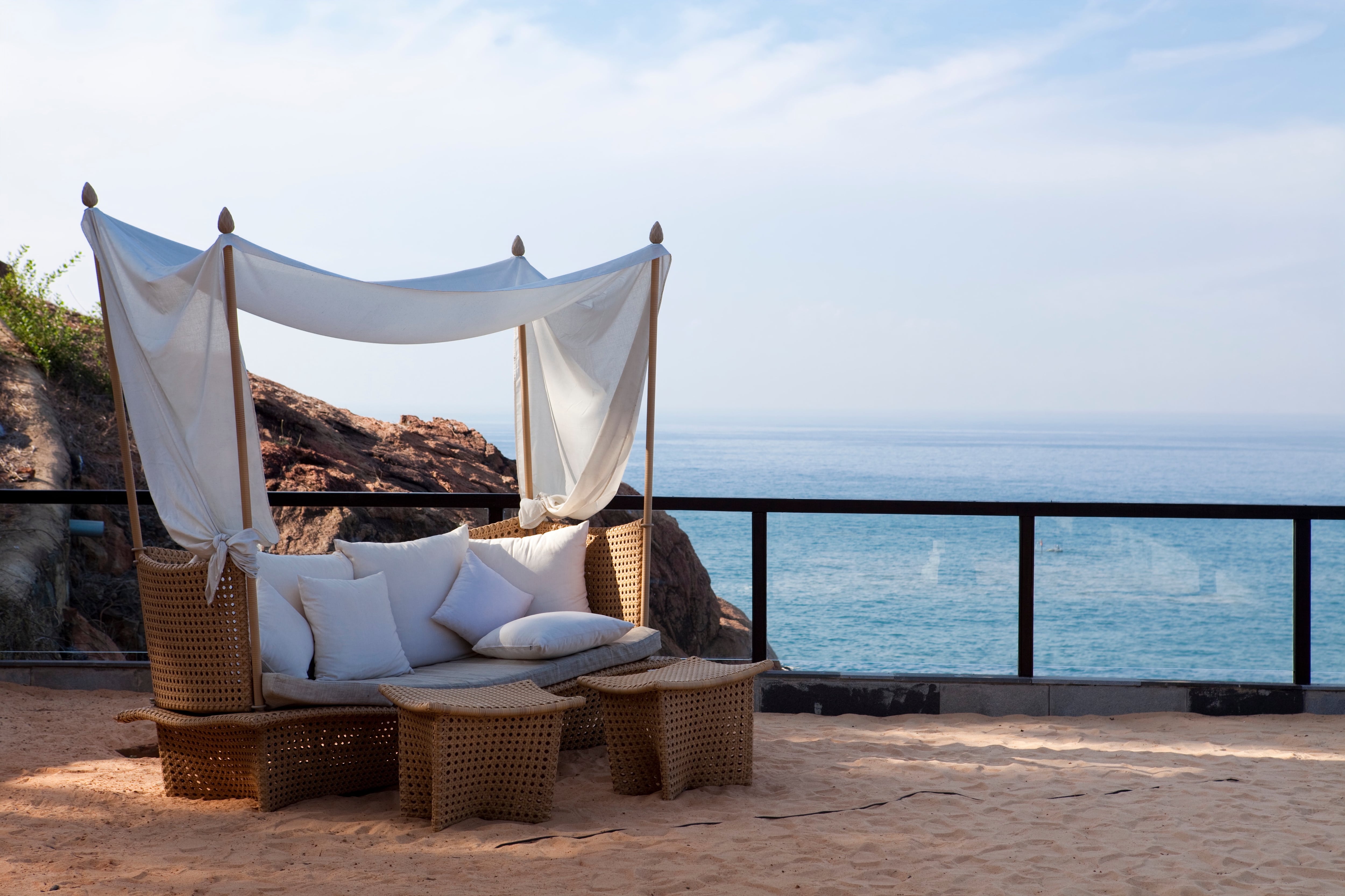 A covered loveseat by the ocean