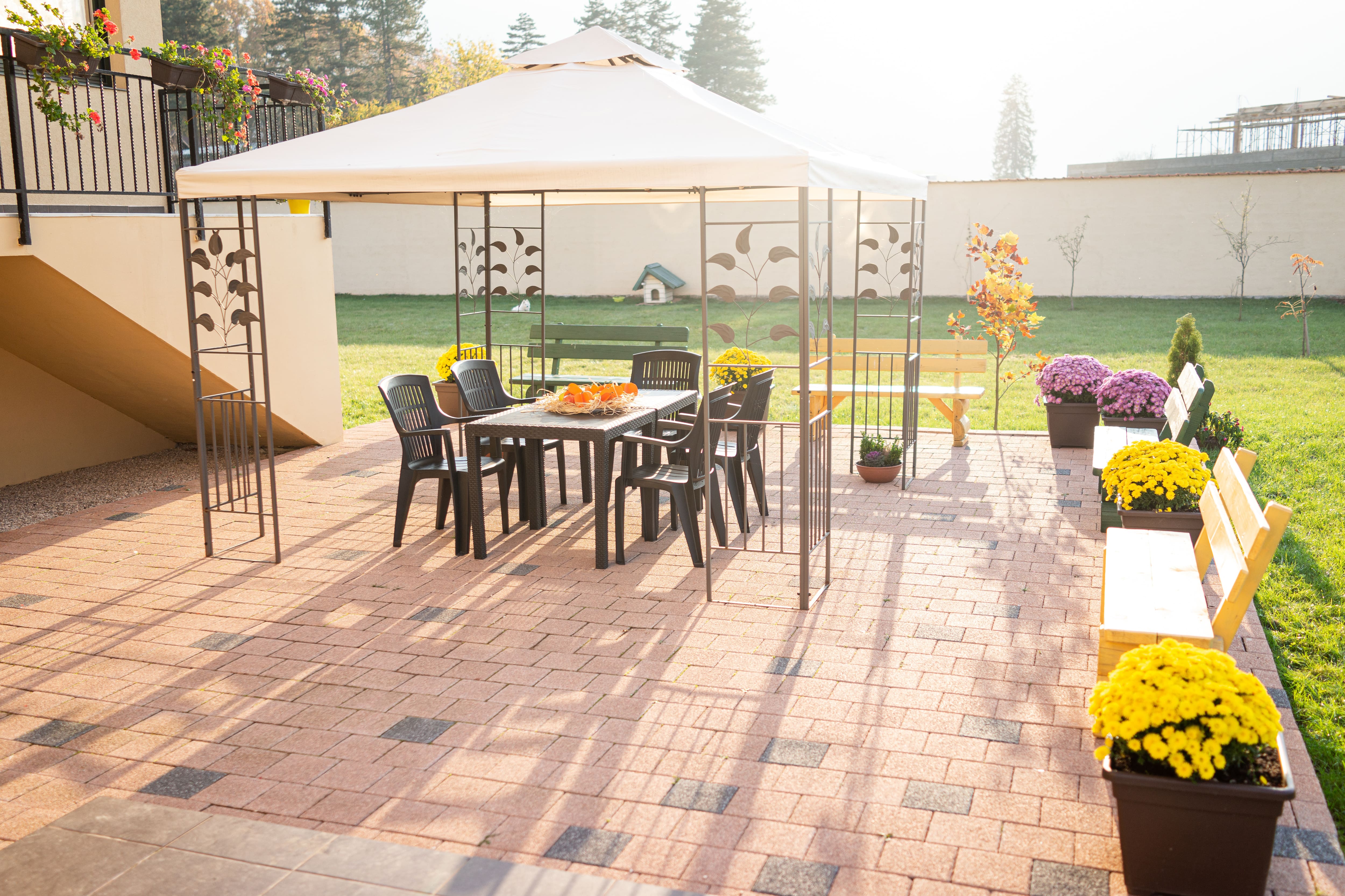 A brick patio with a tent-style canopy cover and dining area