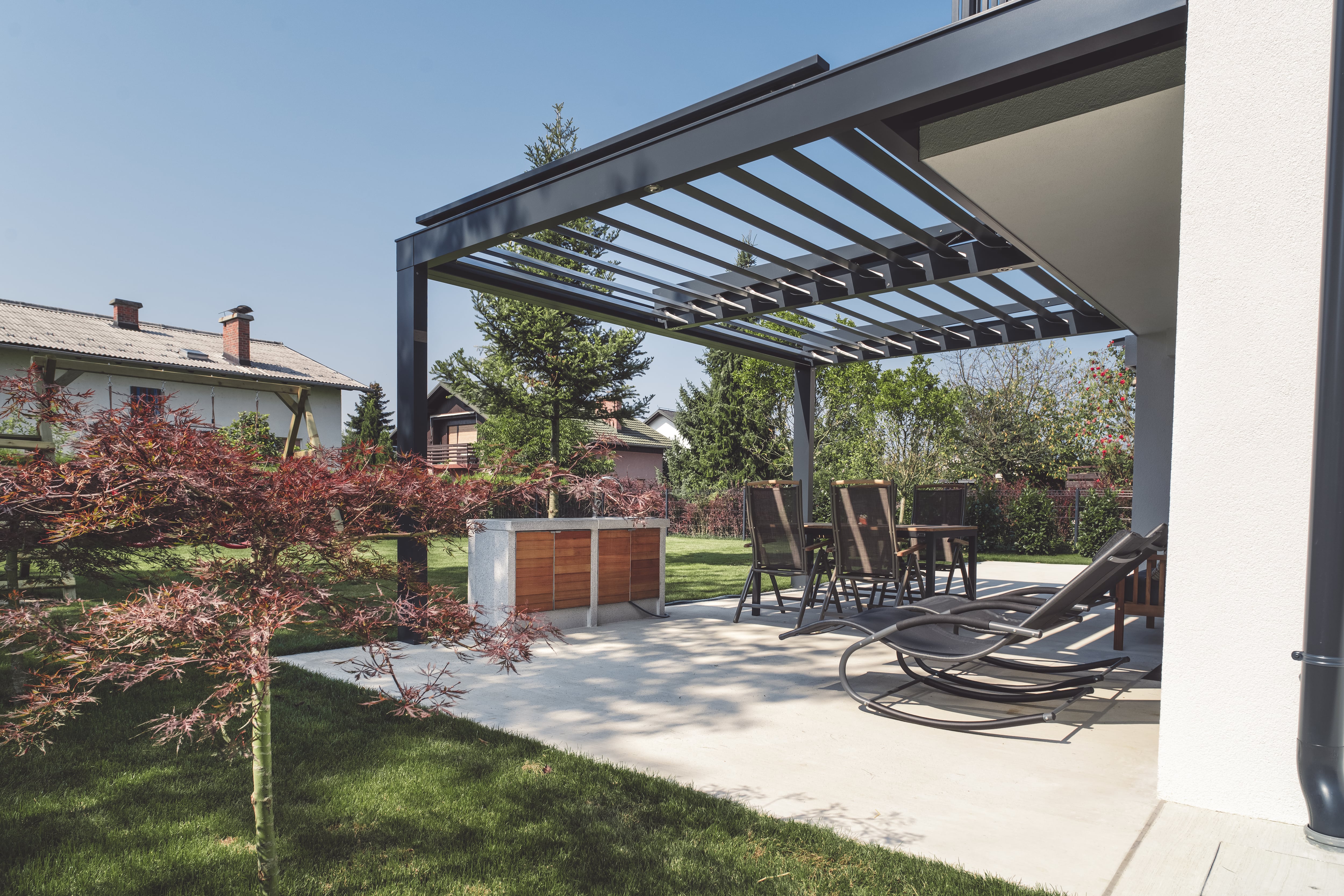 A patio with a modern metal pergola cover