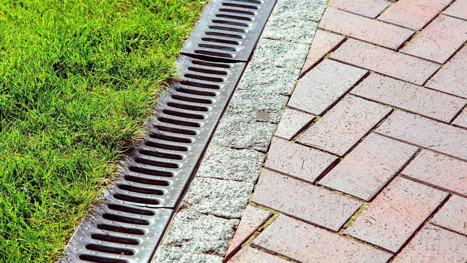 Drainage installed between the lawn and the patio pavers