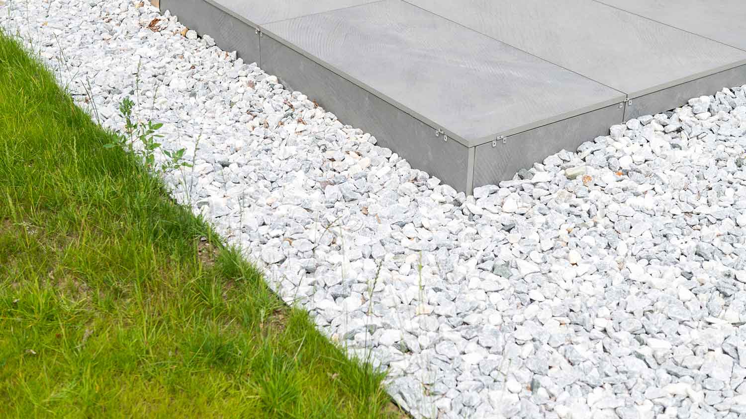 Concrete patio surrounded by small gravel  