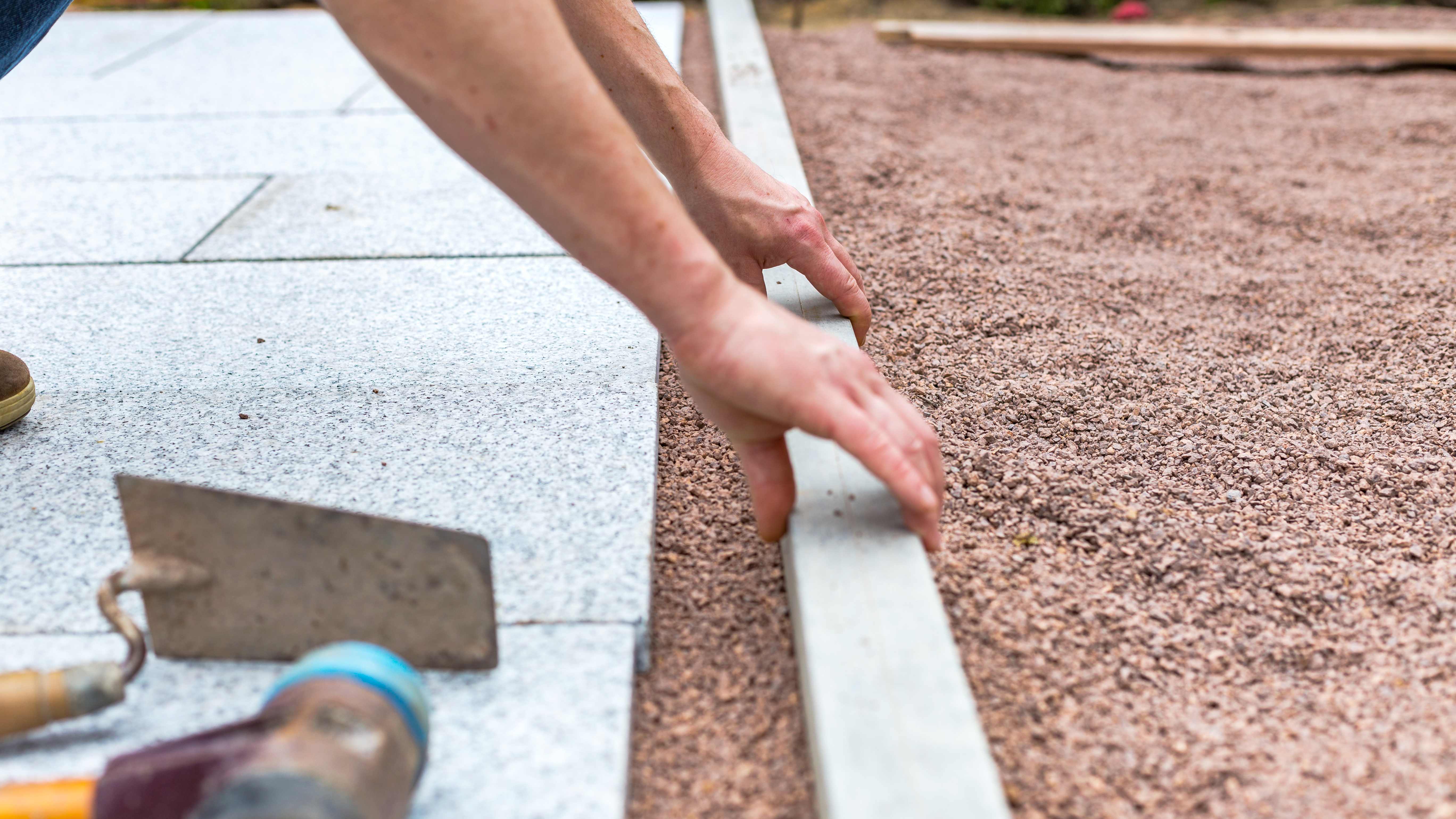 Contractor installing gravel base for a patio 