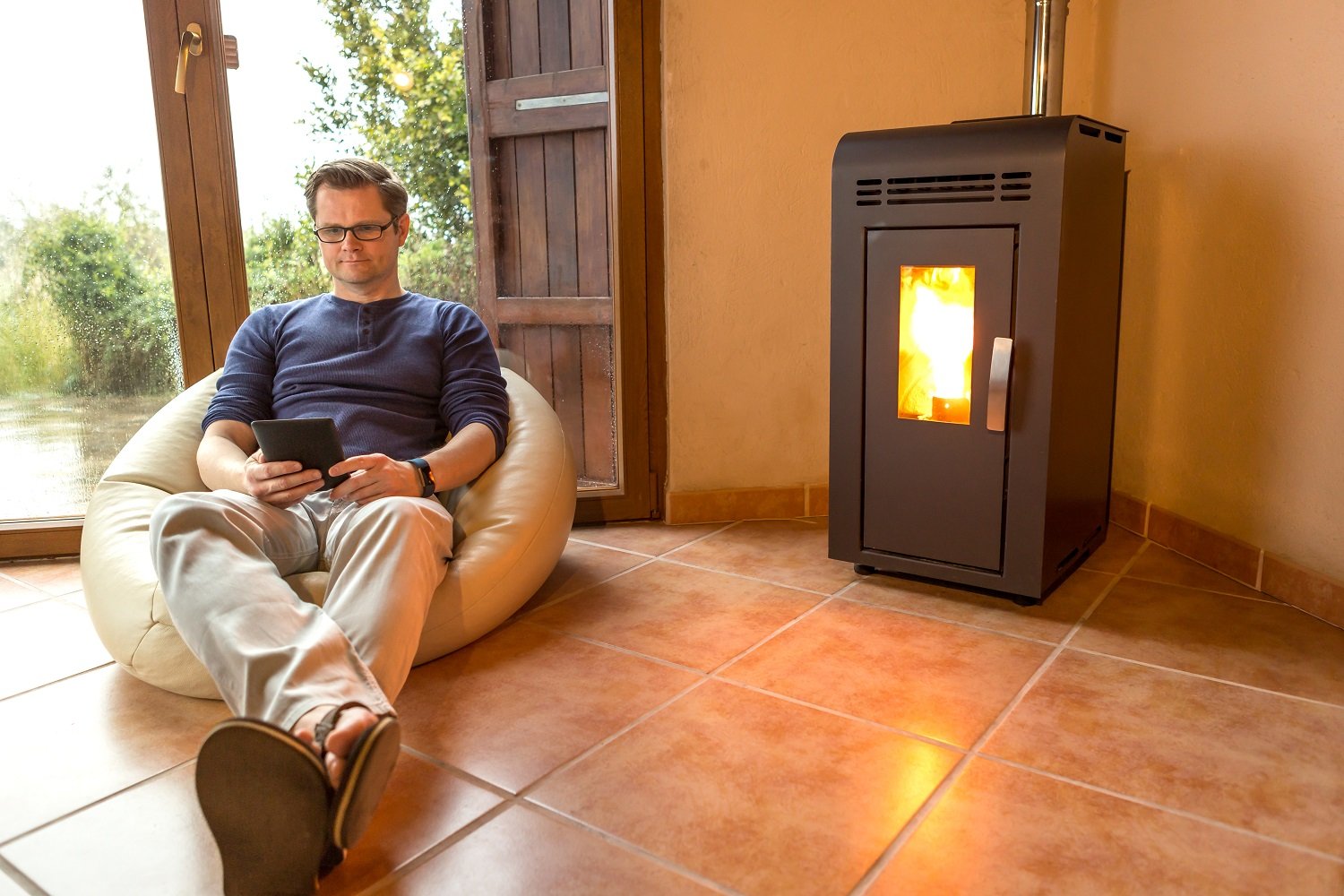 Man sits in front of pellet stove