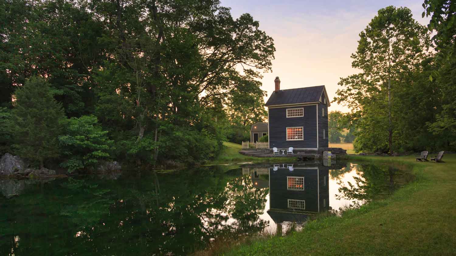 A peppercorn painted cottage built by a pond