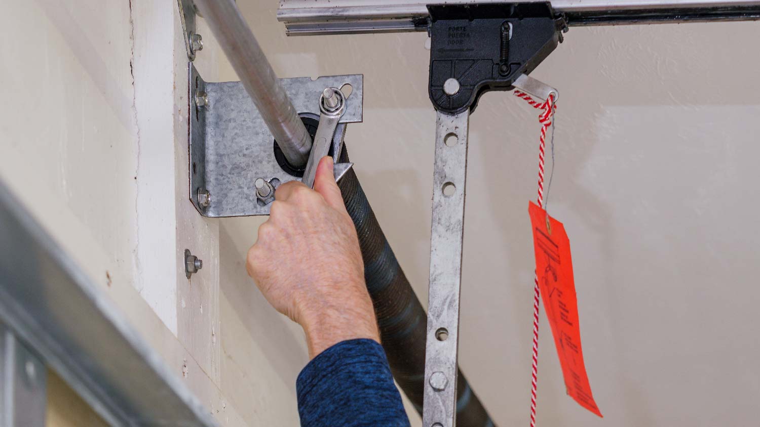 A person adjusting garage door torsion spring