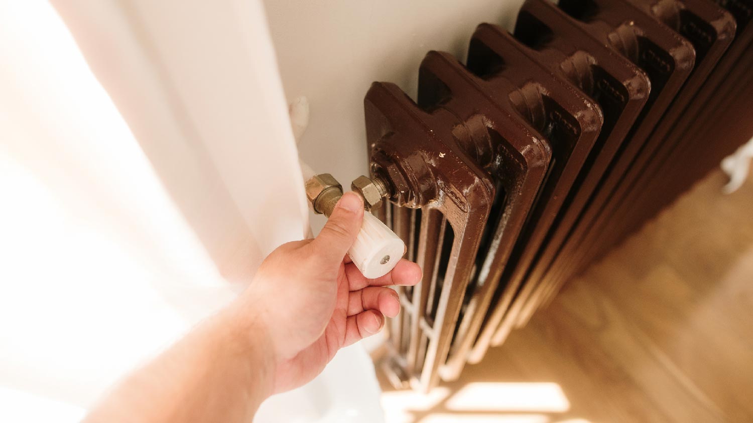 A person adjusting a heat radiator