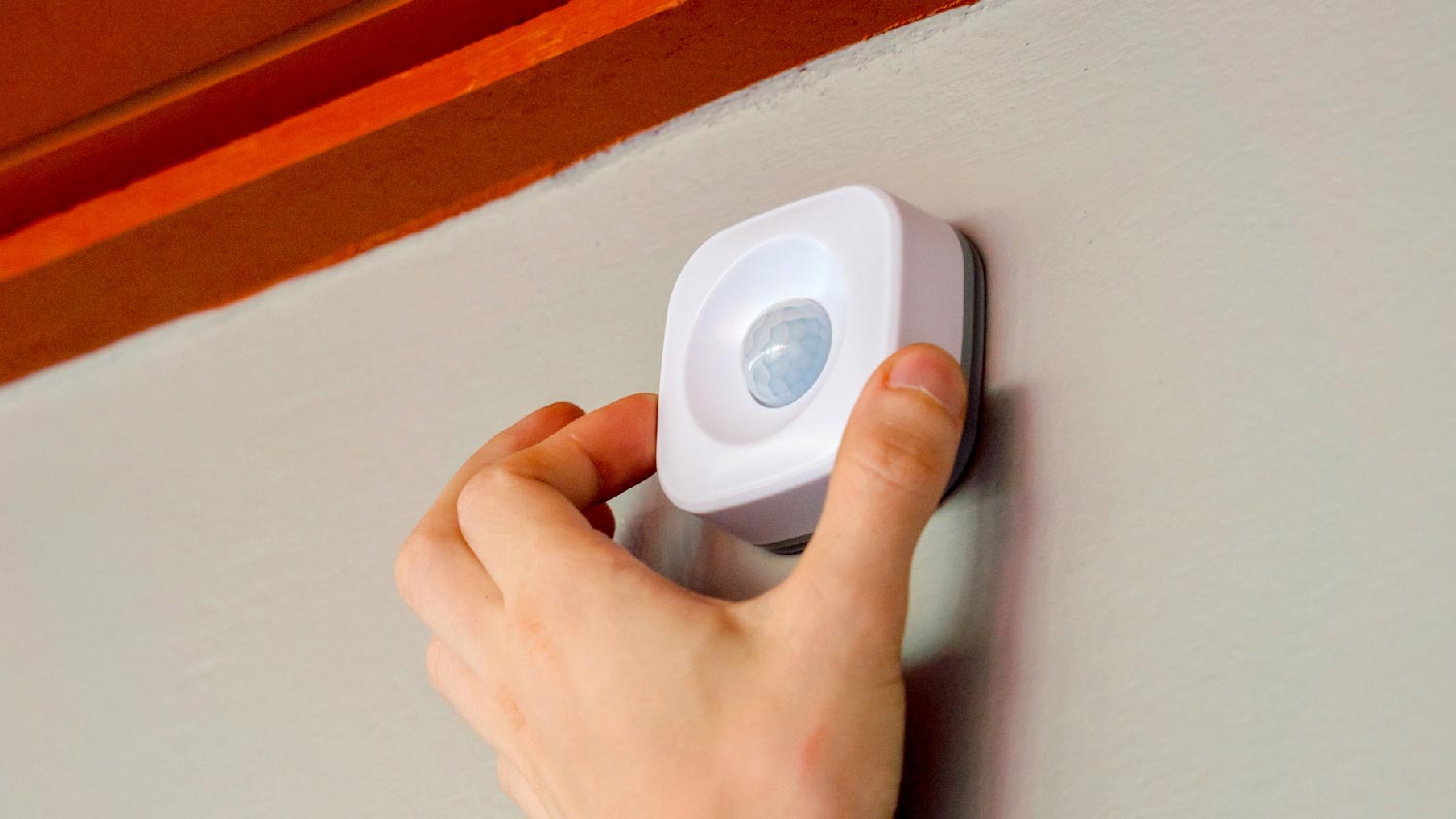 A person adjusting a motion detector