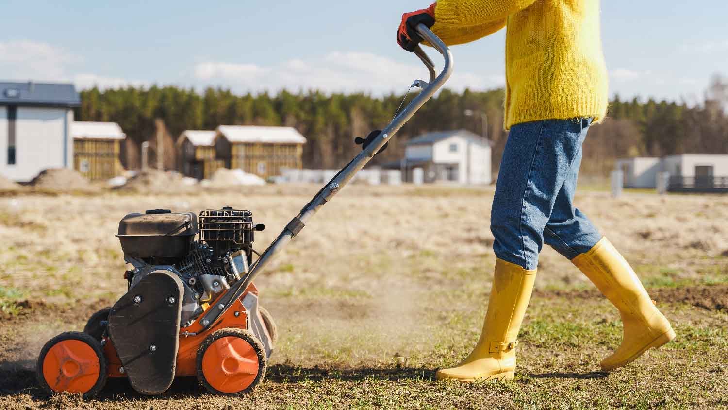 A person aerating lawn with a core aerator