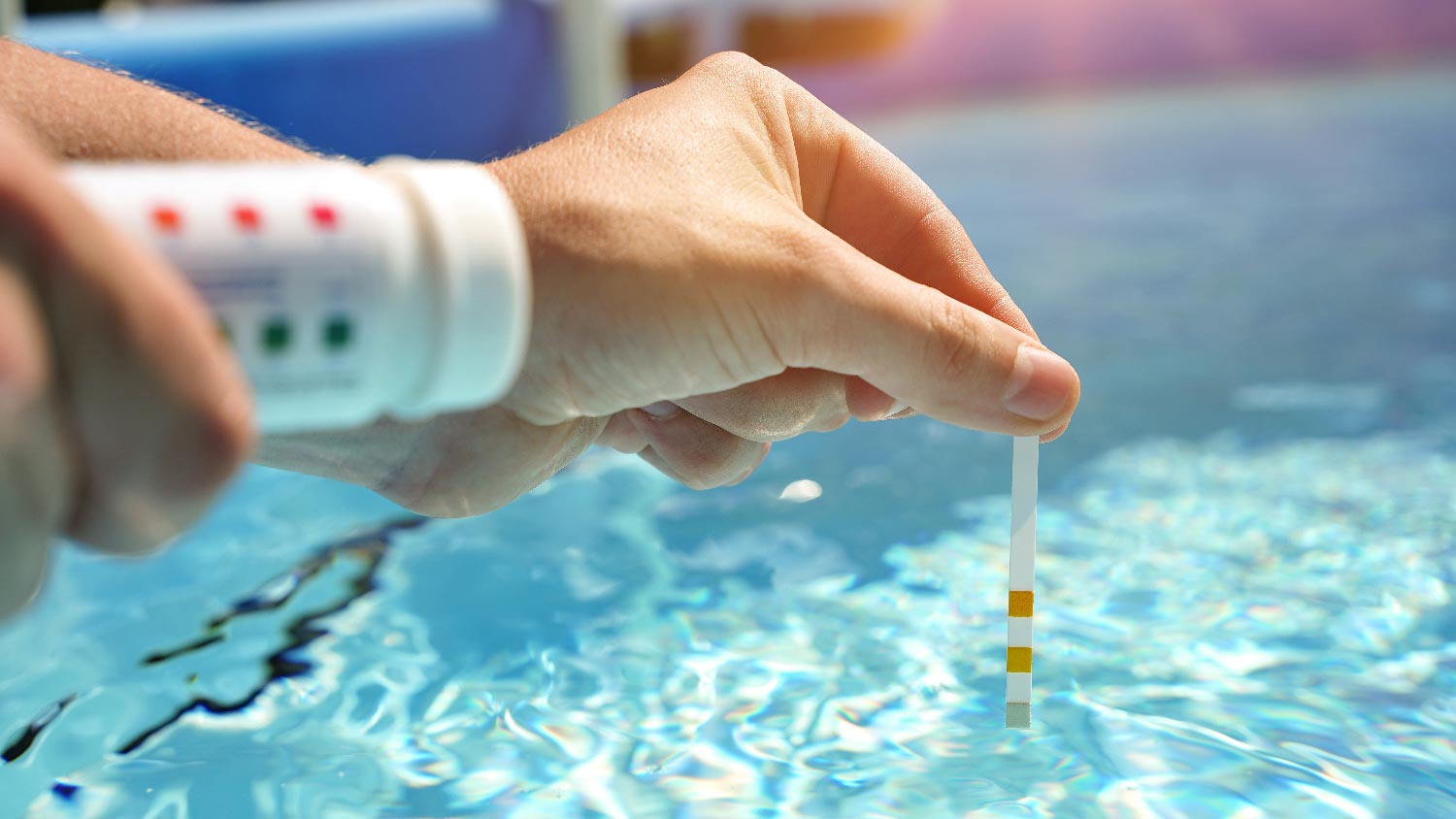 A person checking the water quality of the pool