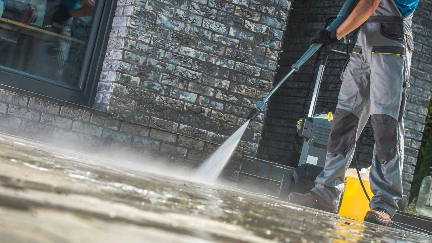 A person cleaning with water a concrete surface