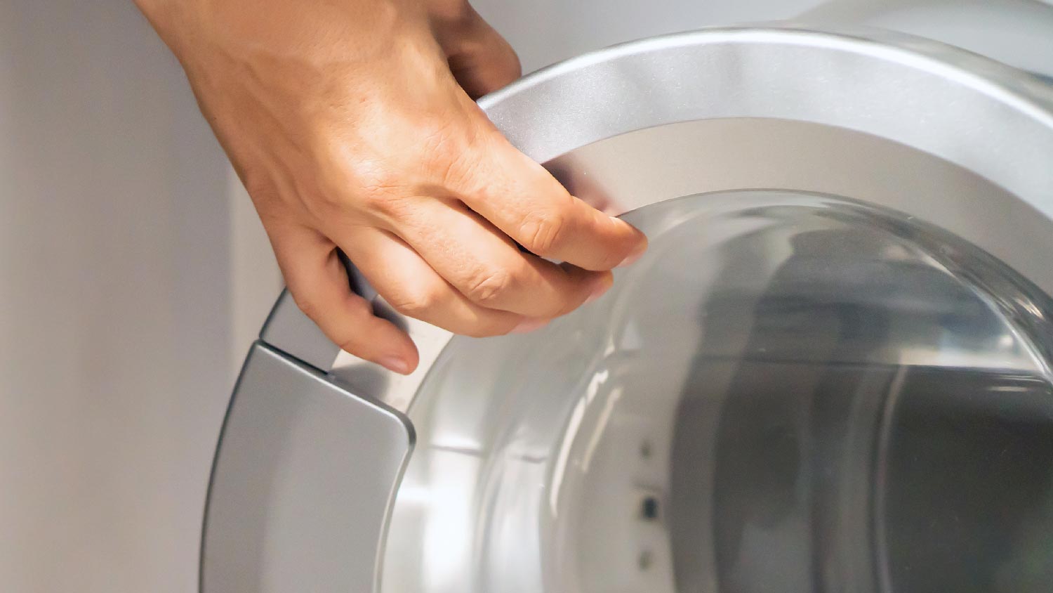 A person closing the dryer’s door