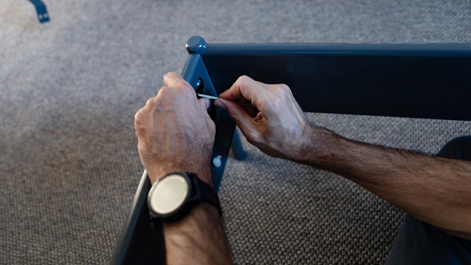 A person dismantling a bed frame