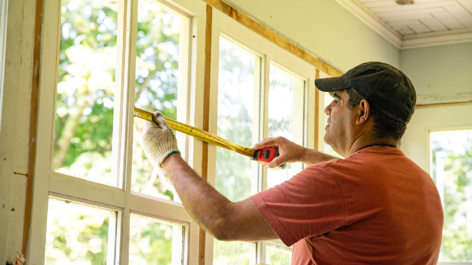 A person finishing up building a sunroom 