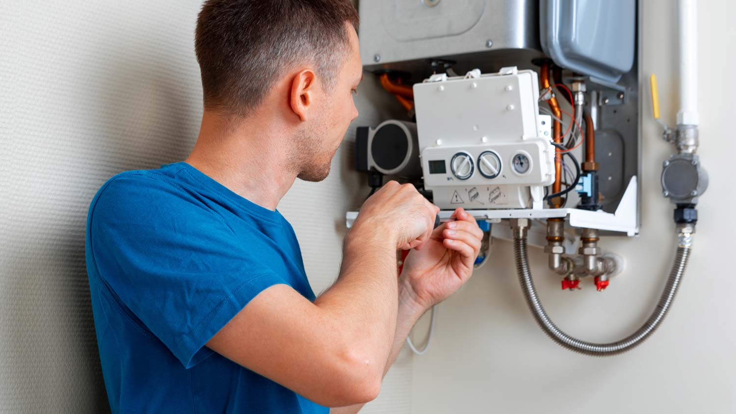 A person fixing a gas water heater 