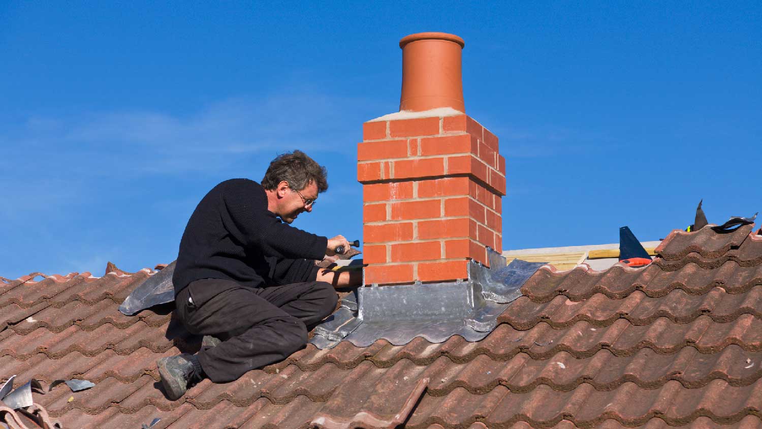 A person inspecting for a chimney leakage