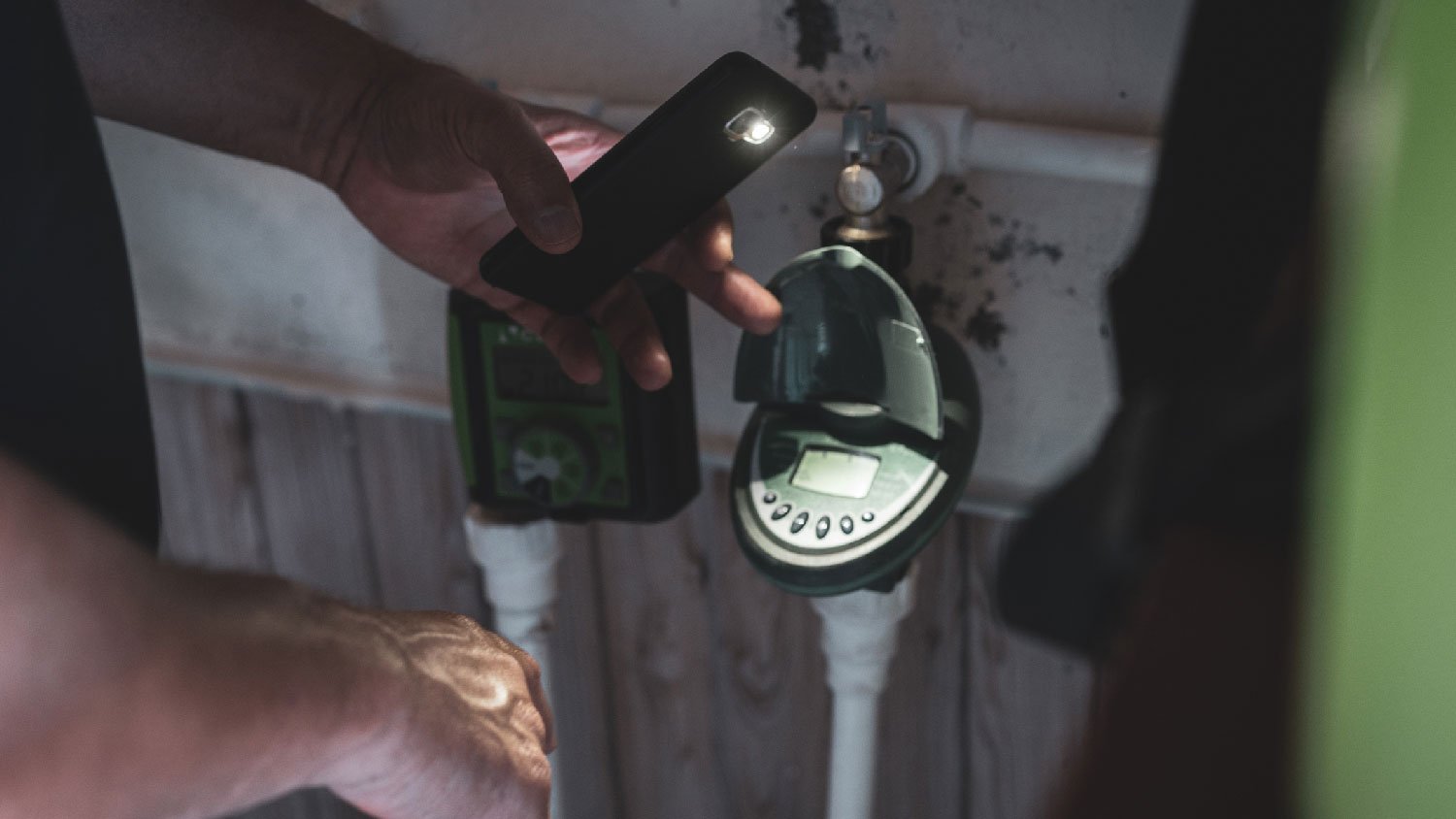 A person inspecting an irrigation controller