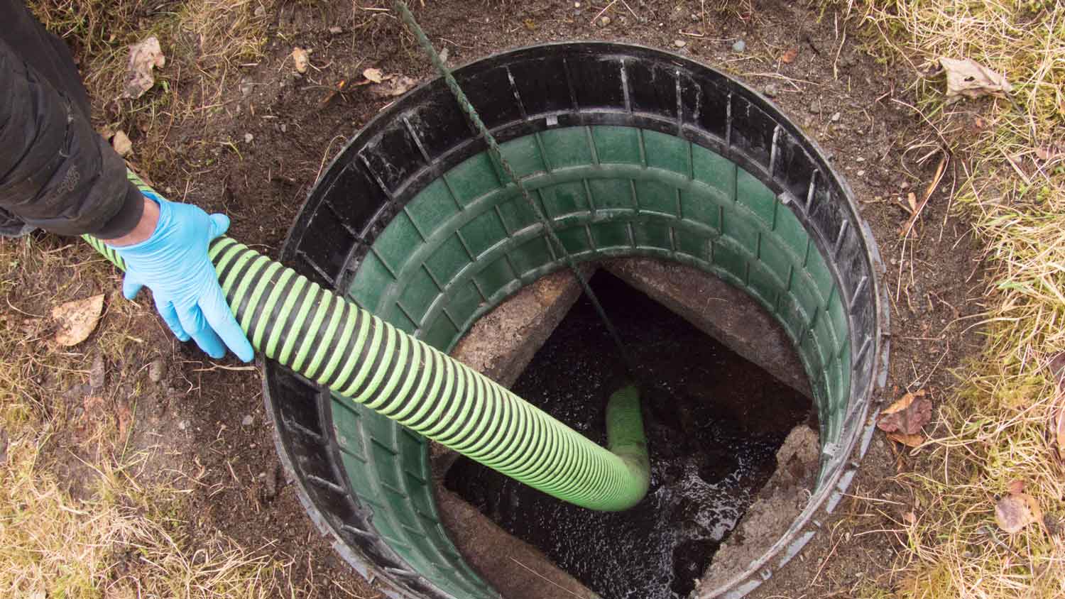 A person inspecting a mound septic tank