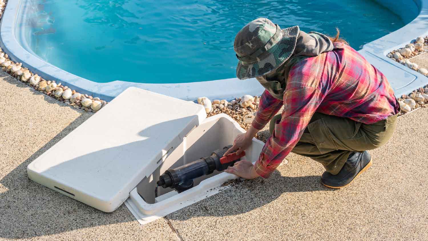 A person inspecting a pool pump