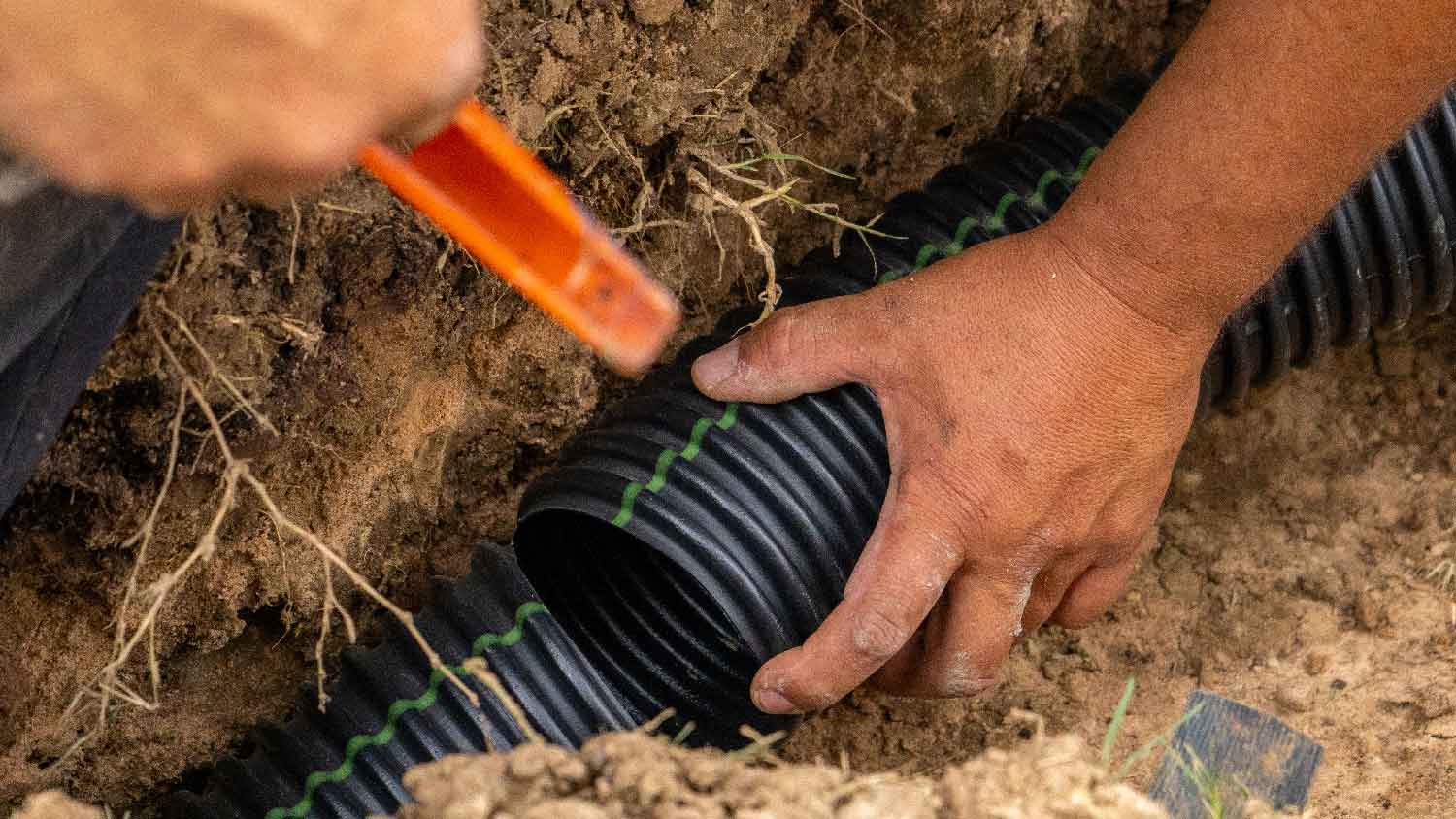 A person installing a drain tile