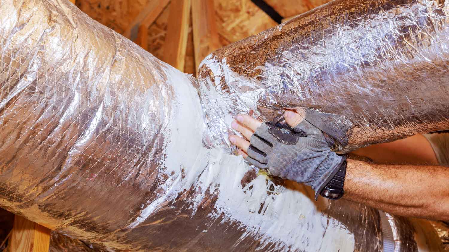 A person installing ductwork