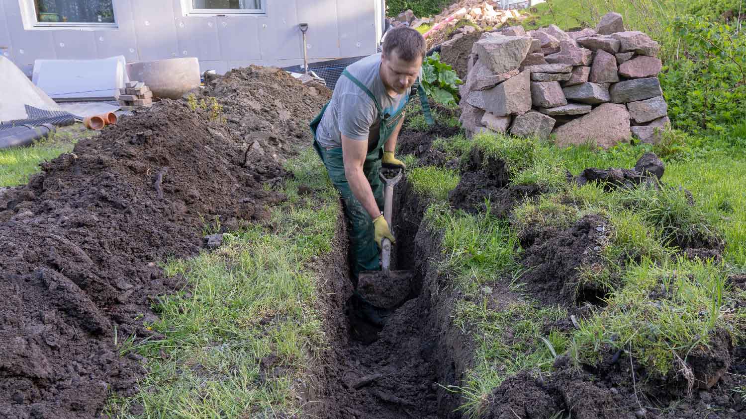 A person digging to install a french drain