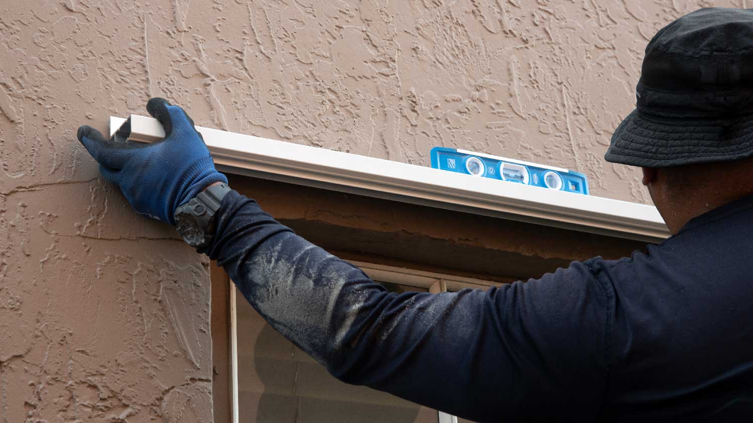 A person installing hurricane shutters