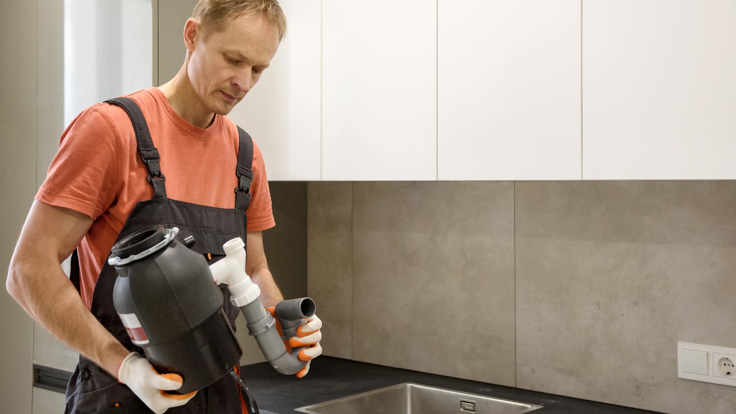 A person installing a new garbage disposal