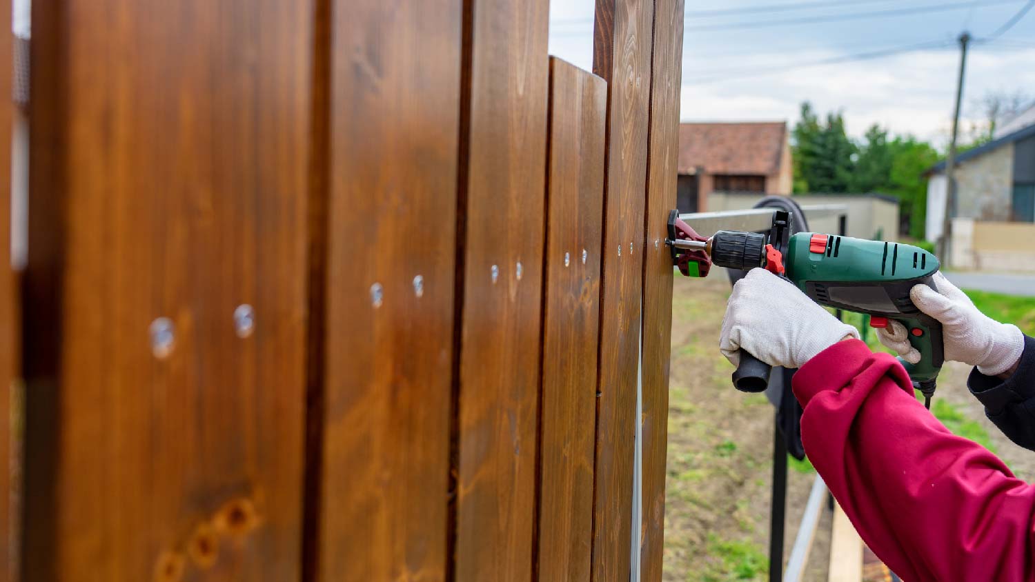 A person installing a privacy fence