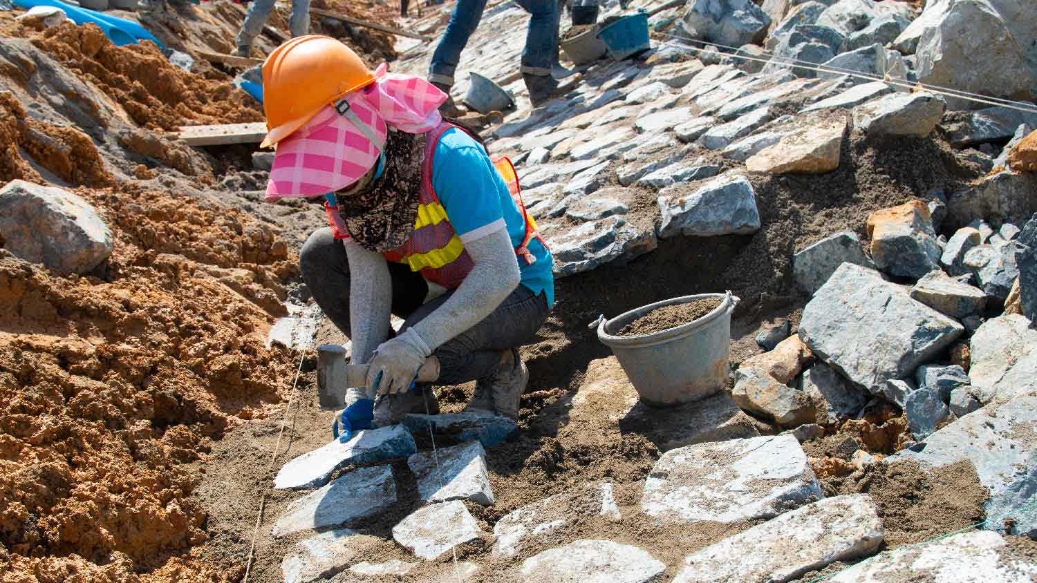 A person installing riprap