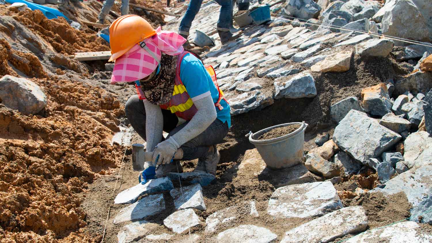 A person installing riprap 